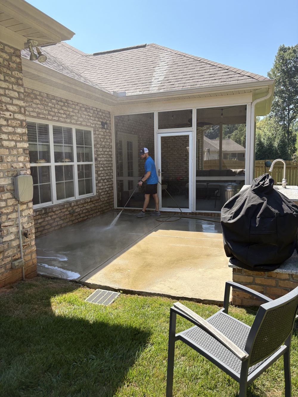 Carolina Home Services team member pressure washing a patio